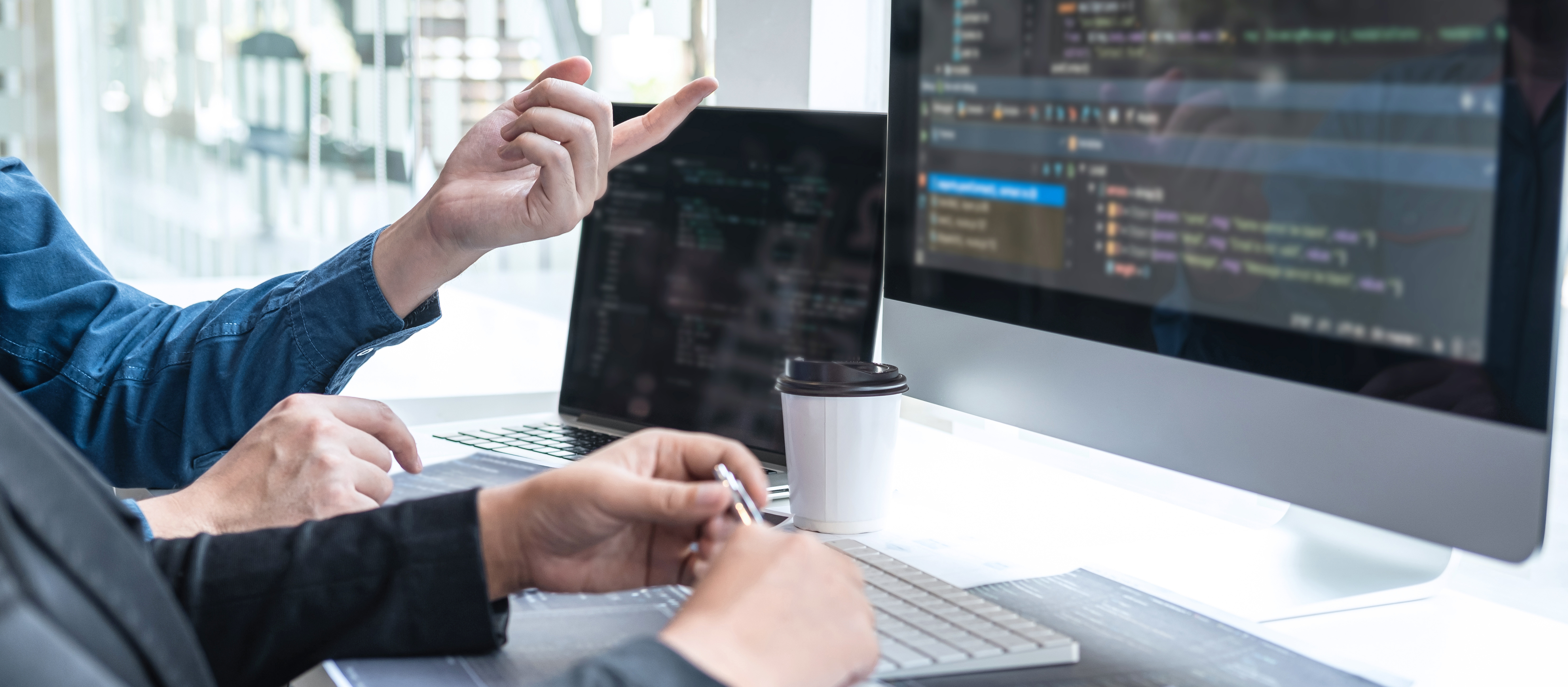 開発者がノートパソコンでコーディング作業をしている様子